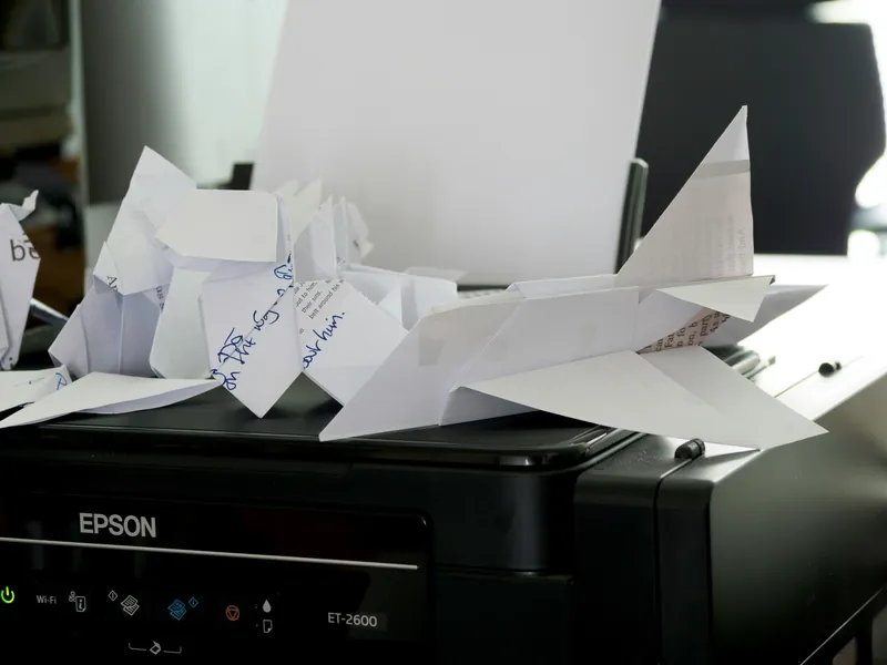 An Epson ink tank printer with printed sheets in the output tray