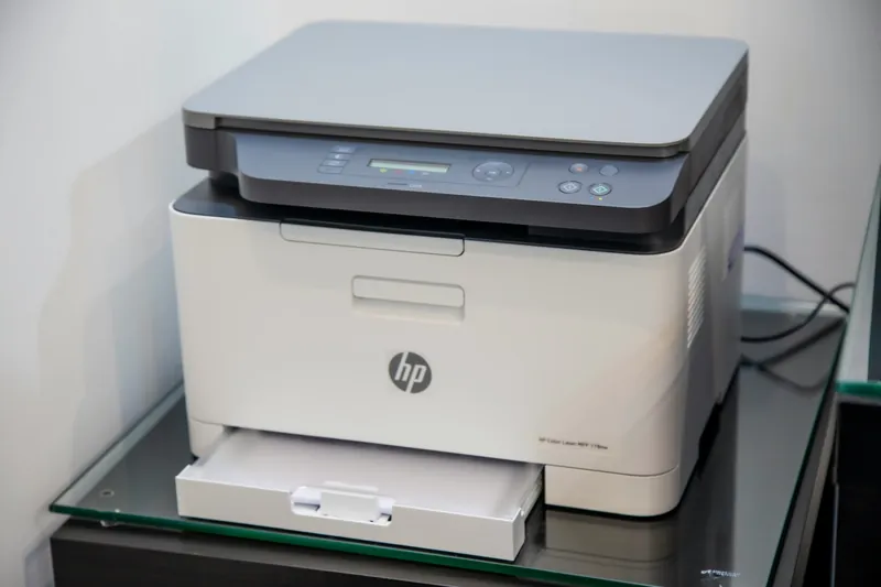 An HP colour laser multifunction printer on a glass stand