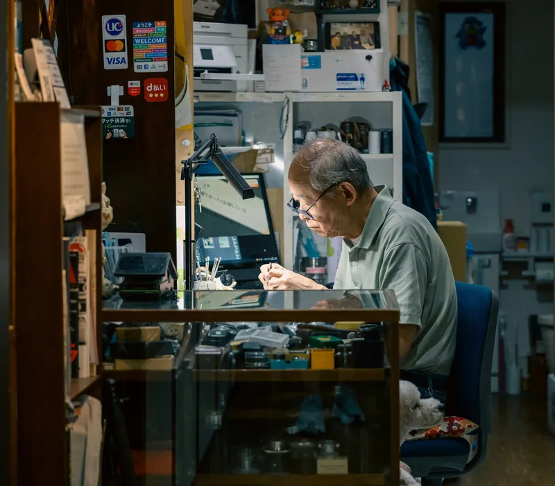 A technician working at a bench surrounded by tools and components